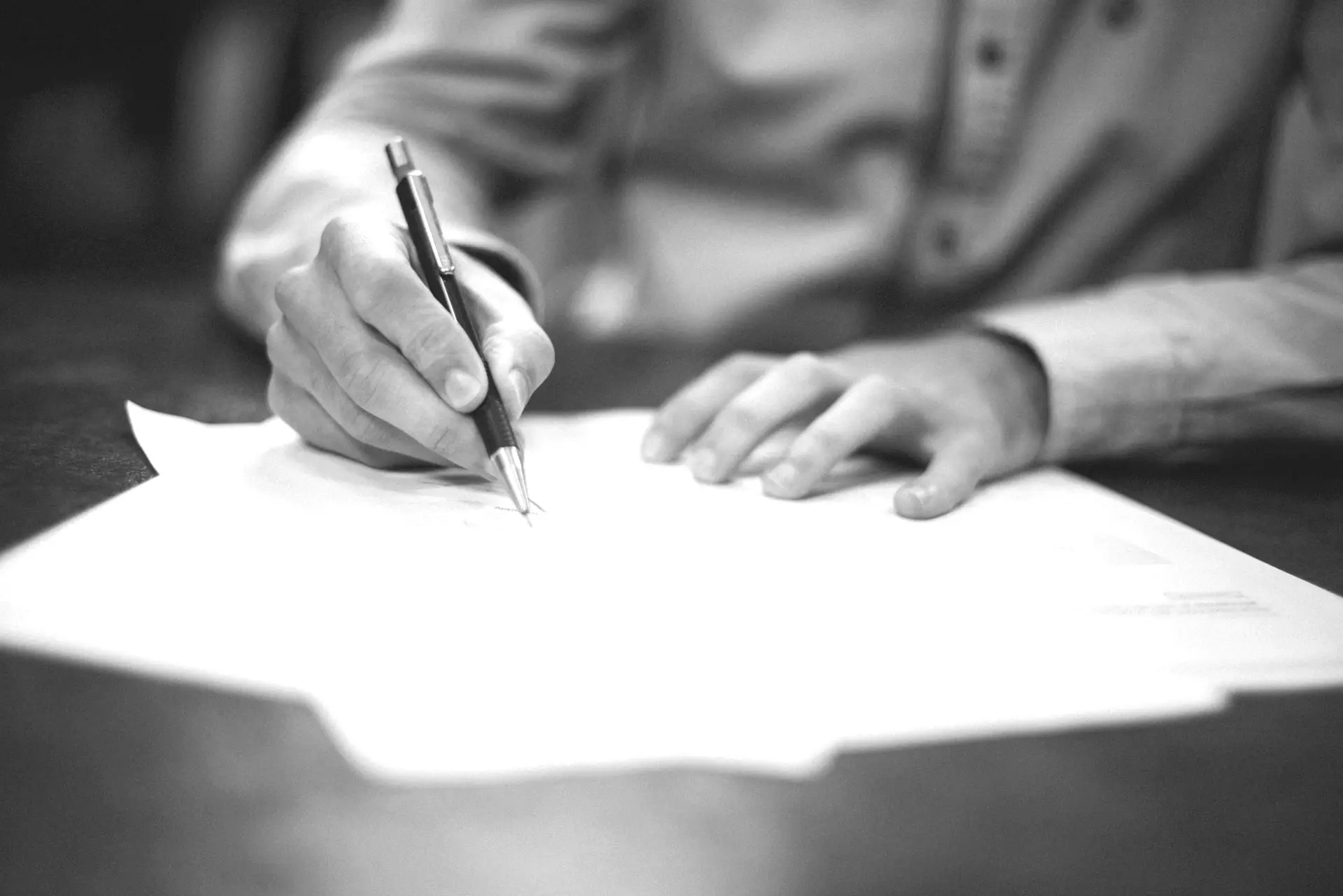 man writing on paper
